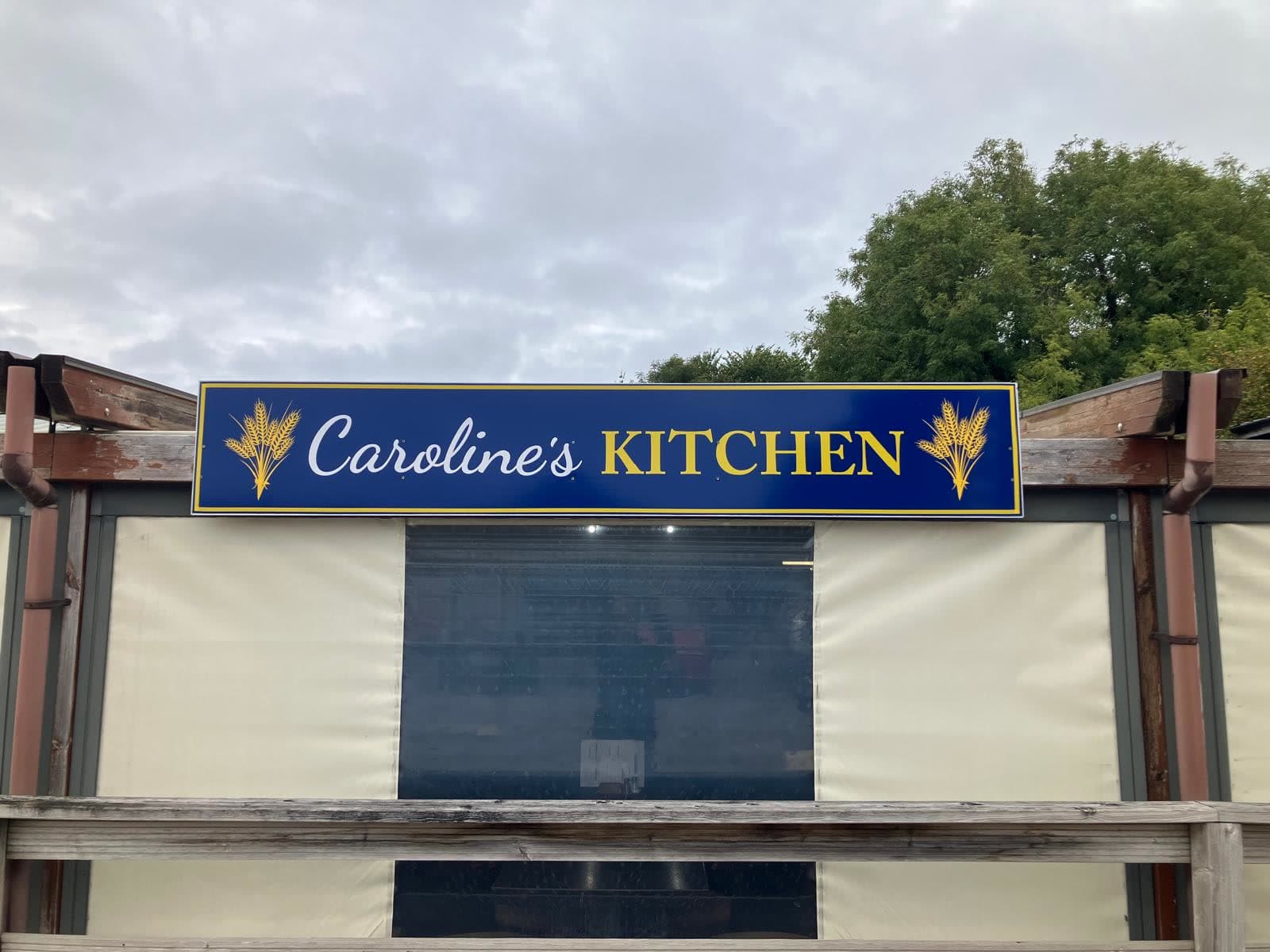 The blue and gold Caroline's Kitchen sign above the café windows